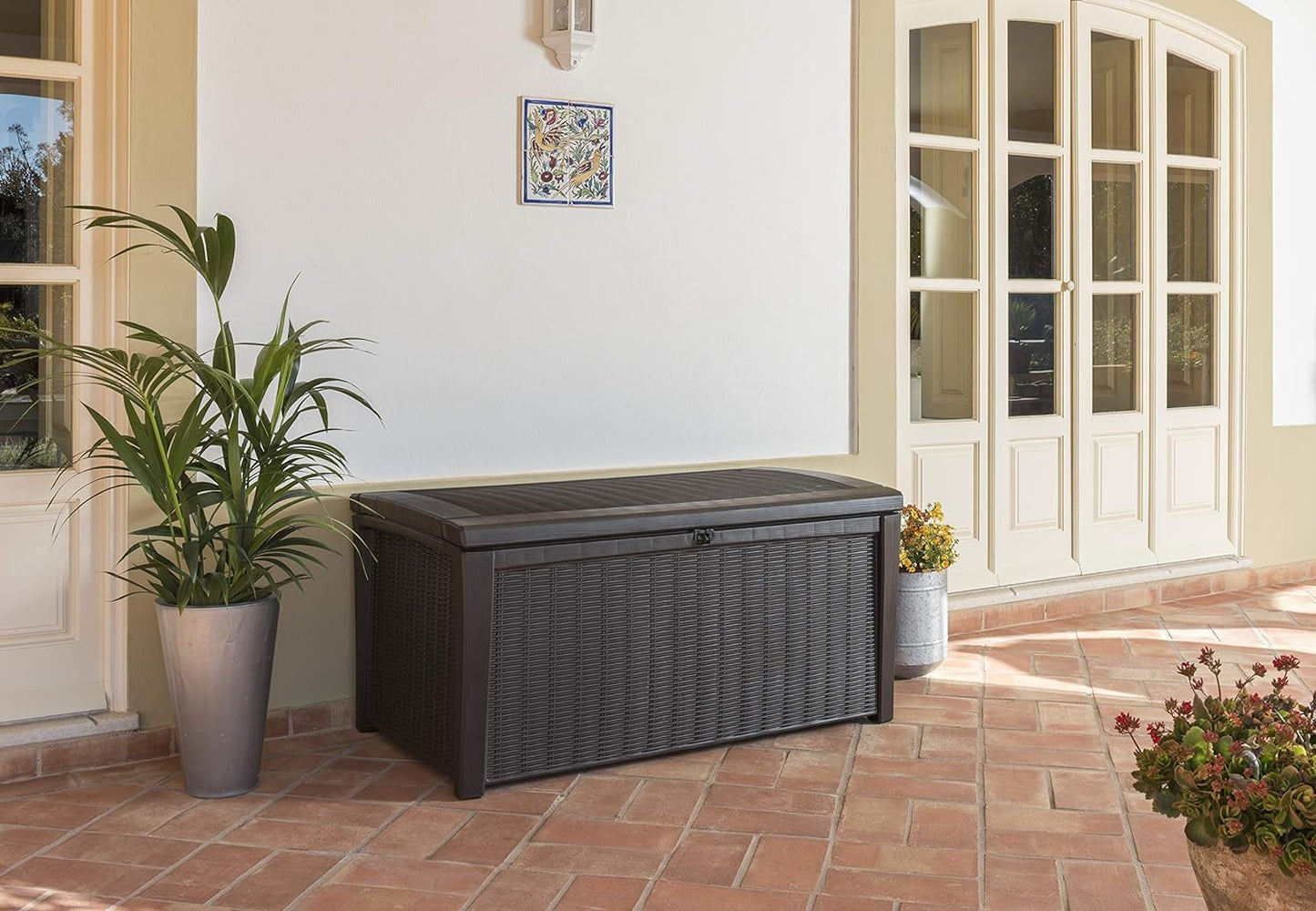 Two adults sitting on the closed storage box on a patio, shown as bench seating