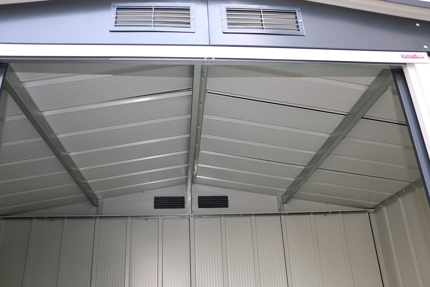 Interior base corner showing galvanized metal floor frame and ribbed panel junctions