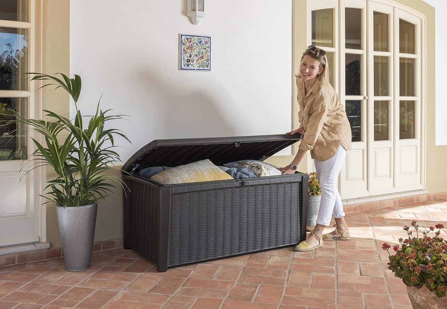 Open storage box in a garden setting with cushions inside and a 60% recycled materials badge overlay