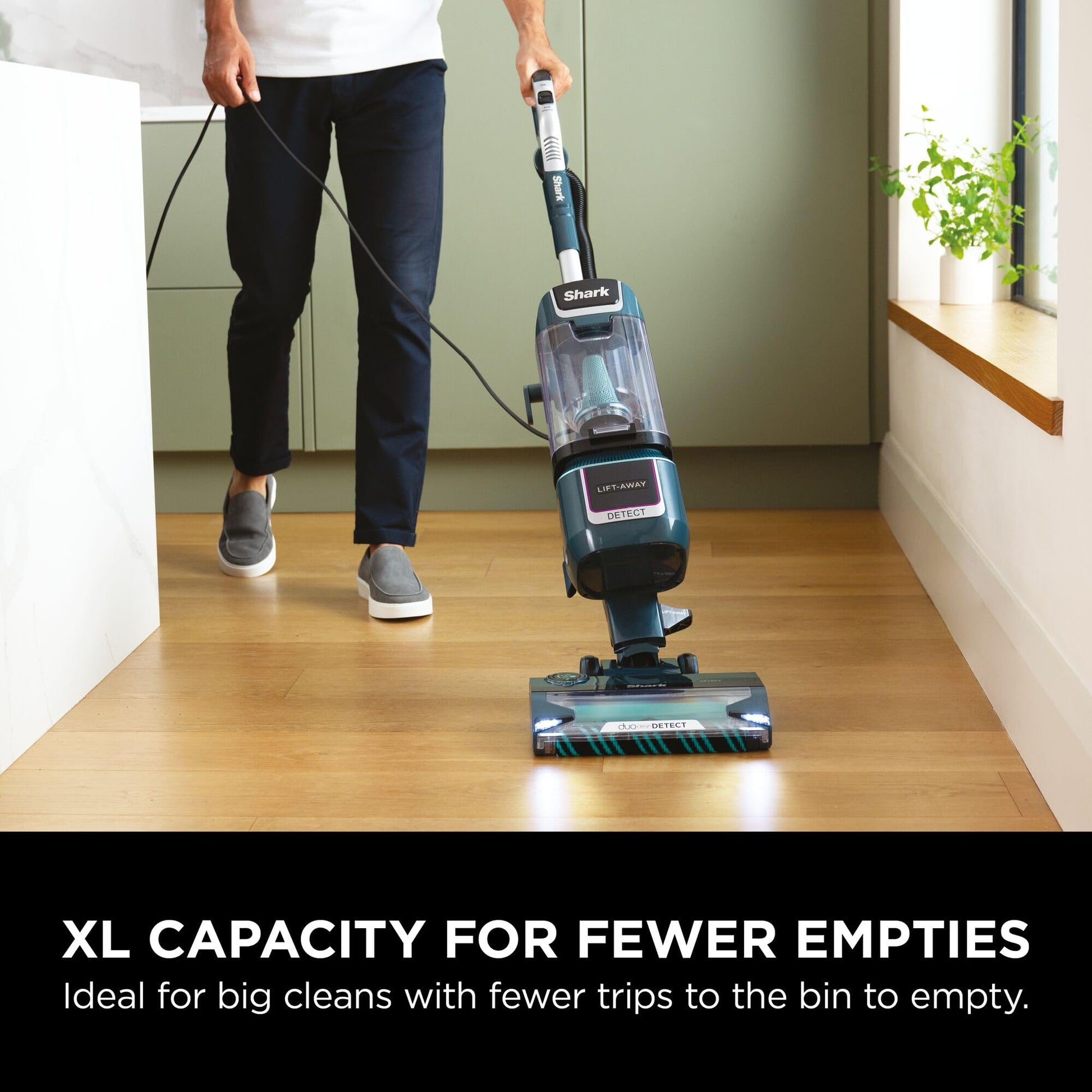 Person pulling the upright vacuum across the floor, showing the lift‑away pod and handle in use
