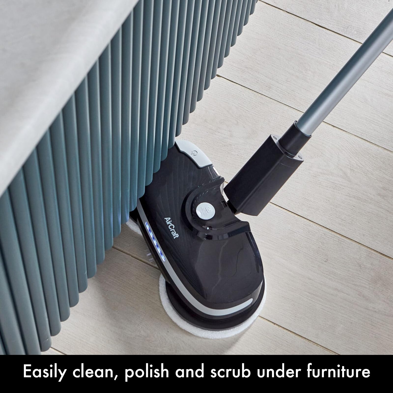PowerGlide angled to reach and clean under low furniture, twin pads working in a narrow gap