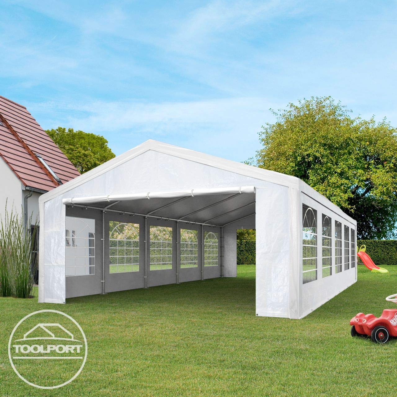 Open white party tent in a backyard showing frame and arched window panels, house and children's slide nearby
