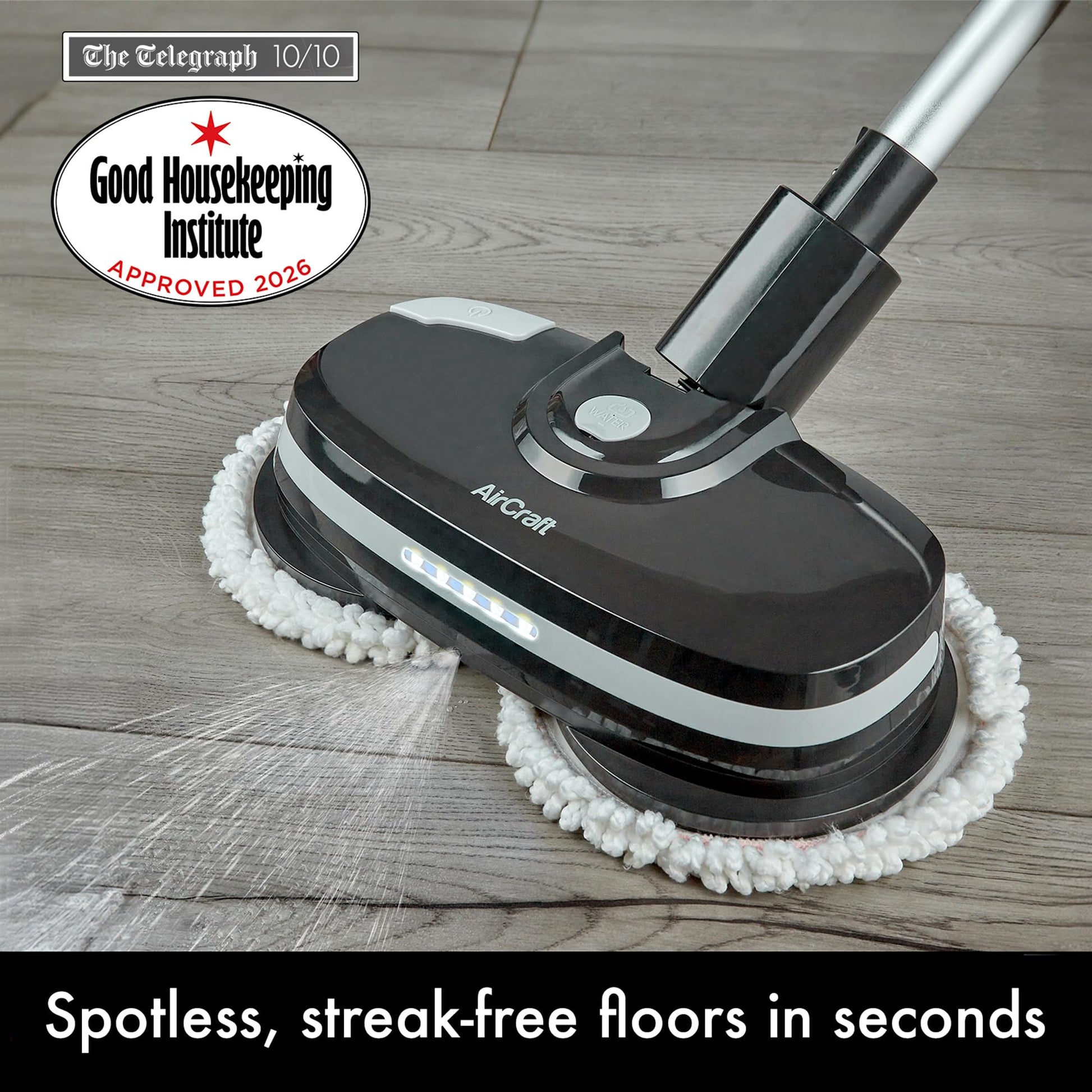 Close-up of PowerGlide head on wood floor showing LED lights, water spray and Good Housekeeping approval badge