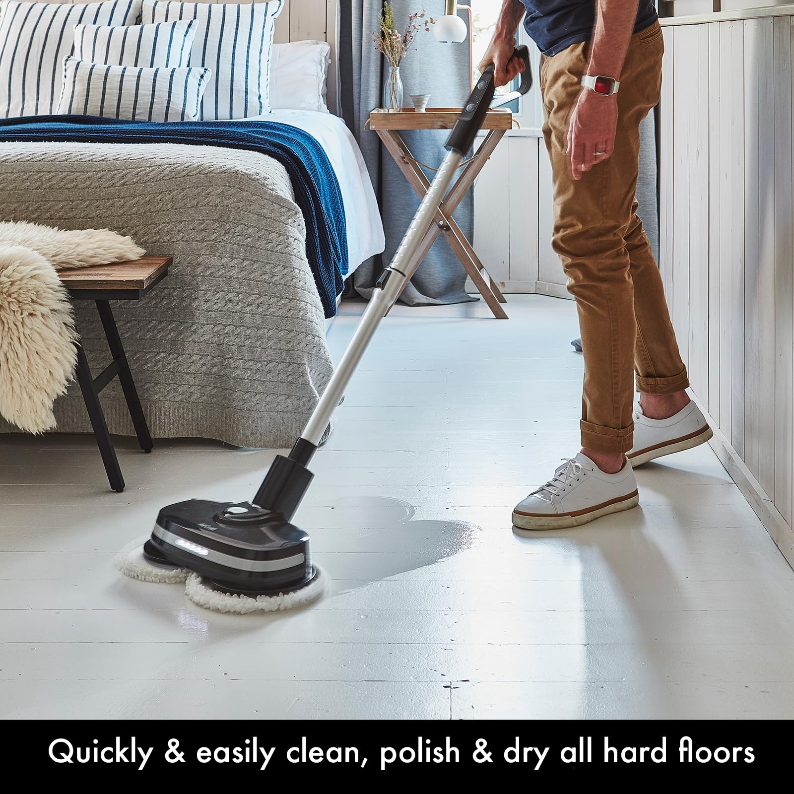 Person using PowerGlide in a bedroom to clean painted wood floor, twin pads and wet cleaning visible