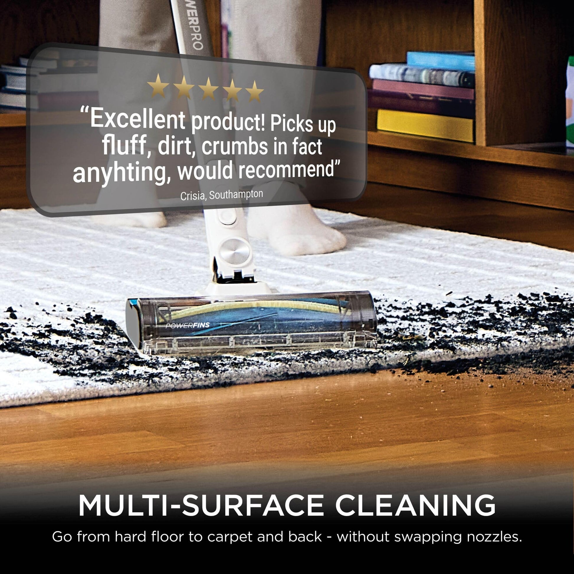 Shark stick vacuum cleaning thick pet hair from a carpet, showing clumps of fur being picked up by the motorised head.