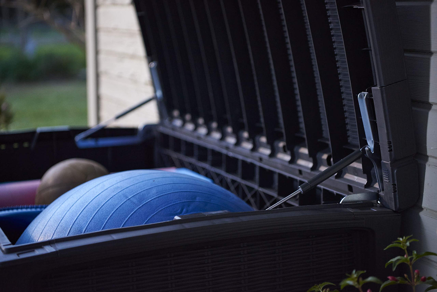 Brass padlock secured to the storage box latch over the rattan-effect front panel
