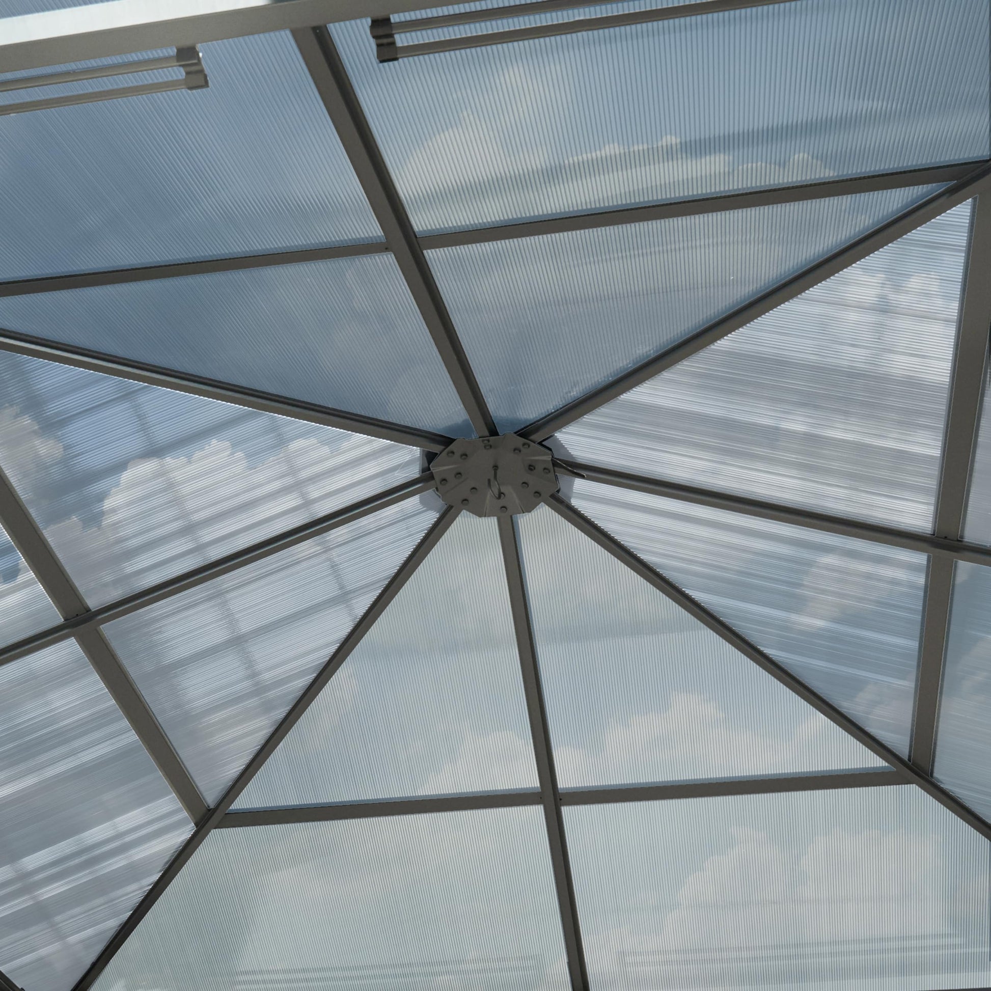 Interior upward view of the gazebo showing the central roof hub and radial aluminium supports beneath the panels.